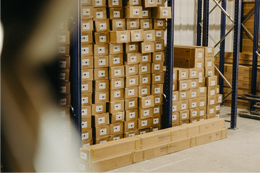 Stacks of cardboard boxes on a pallet in a Pergolux warehouse setting