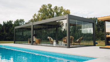 Modern backyard featuring a PERGOLUX pergola over a patio lounge area beside a swimming pool
