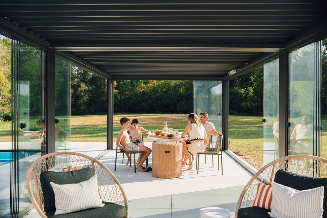 Family enjoying outdoor dining area under a Pergolux pergola beside the pool