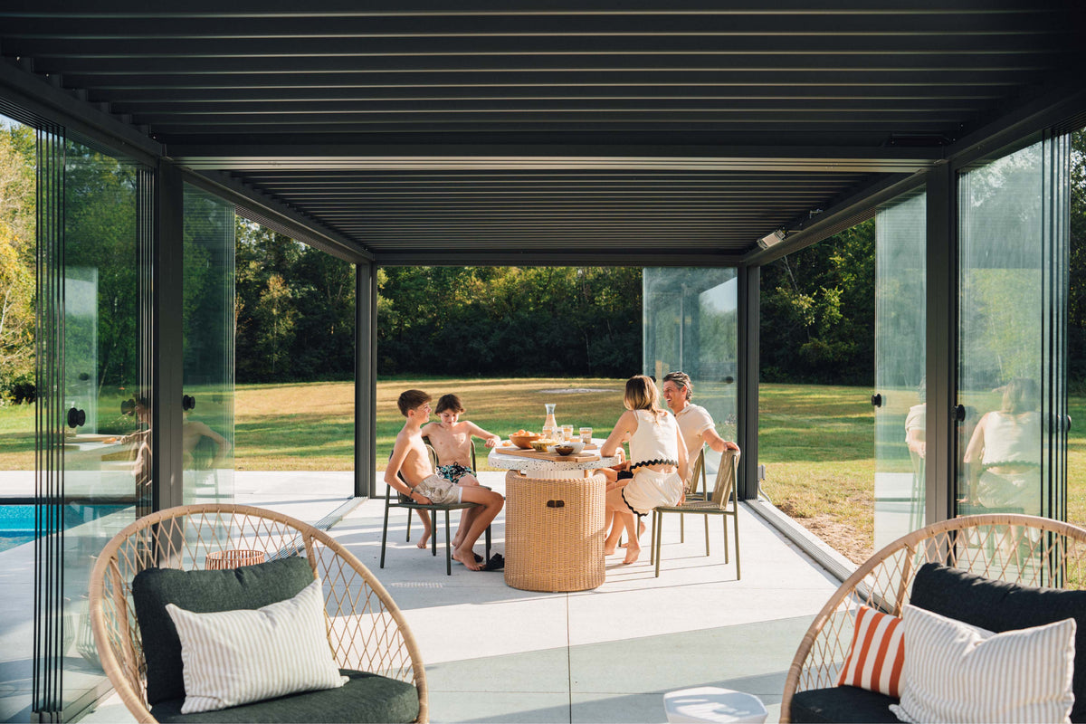 Family enjoying outdoor dining area under a Pergolux pergola beside the pool