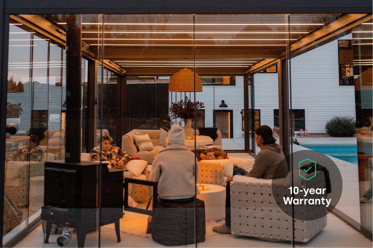 Family enjoying winter weather under a Pergolux Skydance with LED lights, and a heater.