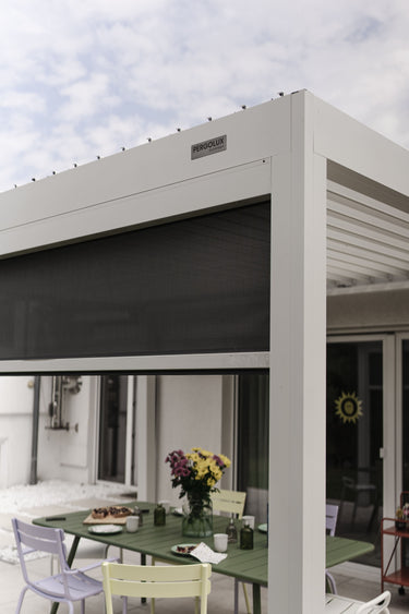 white pergola with dark grey privacy screen and brand label
