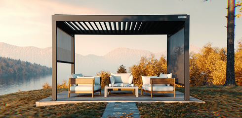 Patio with outdoor furniture under a pergola by a lake during sunset.