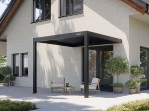 black matte aluminum pergola with PERGOLUX logo shading beige armchairs on paved patio
