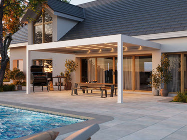 White powder-coated aluminium PERGOLUX Pergola 4 Pro Max with illuminated louvres shading backyard BBQ area