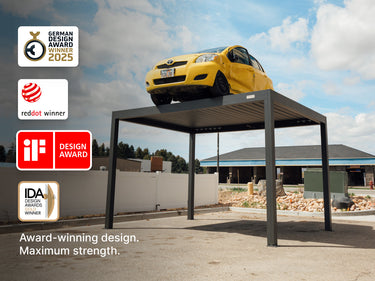 Promotional image showing a yellow car resting on a dark gray pergola roof to demonstrate maximum strength. The image includes four design award badges: German Design Award 2023, reddot winner, iF Design Award, and IDA Design Awards Winner. Text below reads: "Award-winning design. Maximum strength."