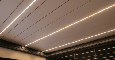 Close-up white horizontal louvered roof panels of PERGOLUX Pergola 4 Pro Max with embedded linear warm white LEDs