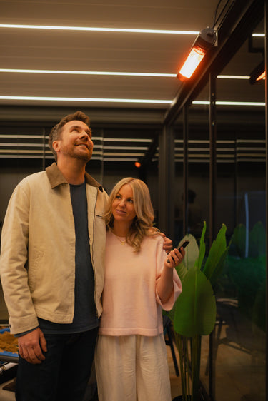 Couple under pergola viewing infrared heater and ceiling lights at night