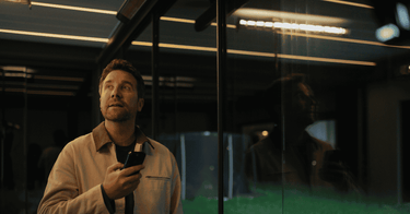 Man using smartphone to control illuminated pergola roof slats via app