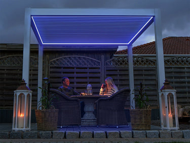 Vibrant blue PERGOLUX LED perimeter lighting creating mood atmosphere in garden pergola at twilight
